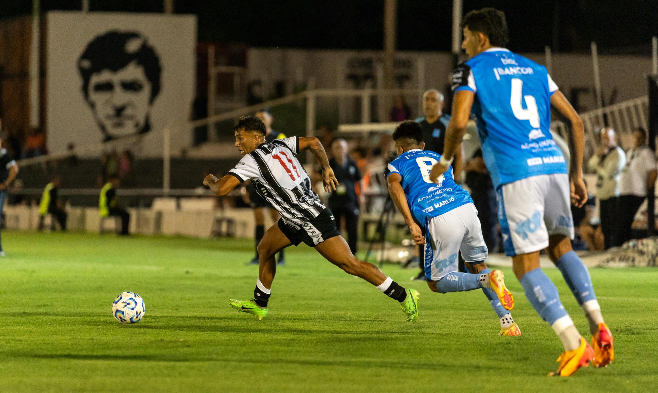Dynamic moment in a soccer match with players in action during a night game on the field.